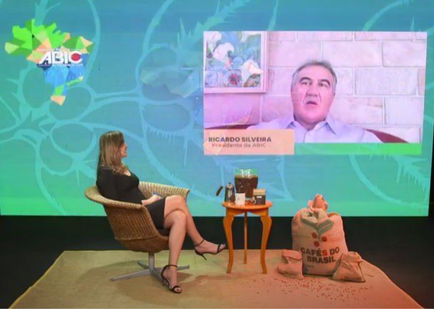 mulher sentada numa cadeira em conversa com participante de evento por videochamada em premiacao da ABIC