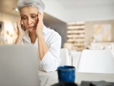 foto mulher cabelo curto trabalhando no computador e com dor de cabeça