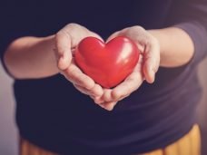 imagem de maos segurando um objeto no formato de coracao vermelho