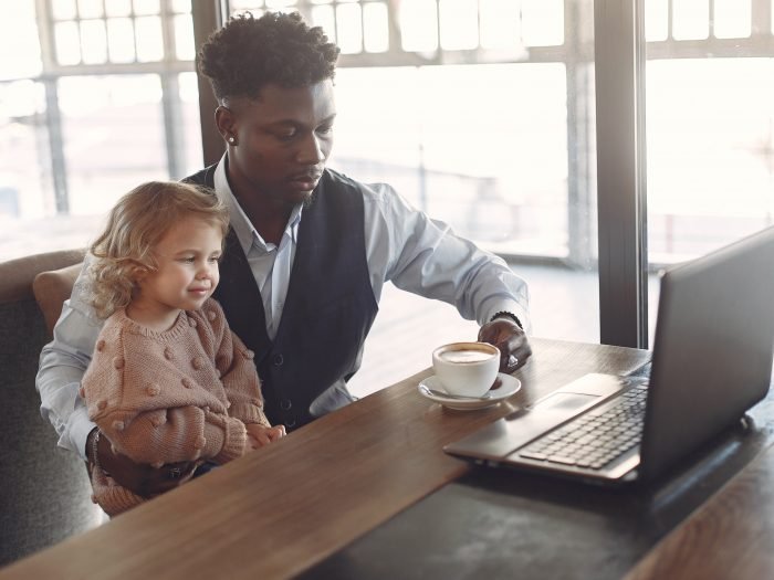 imagem de pai e filha bebendo café em frente ao computador