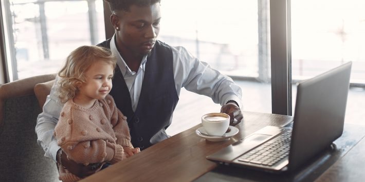 imagem de pai e filha bebendo café em frente ao computador