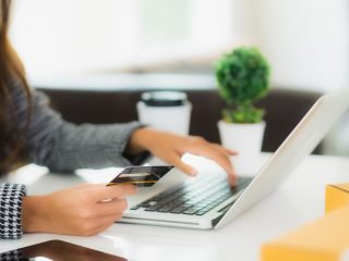 mulher em frente na mesa com computador e xícara de café