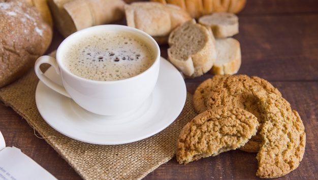 imagem de café sobre a mesa com paes e biscoitos