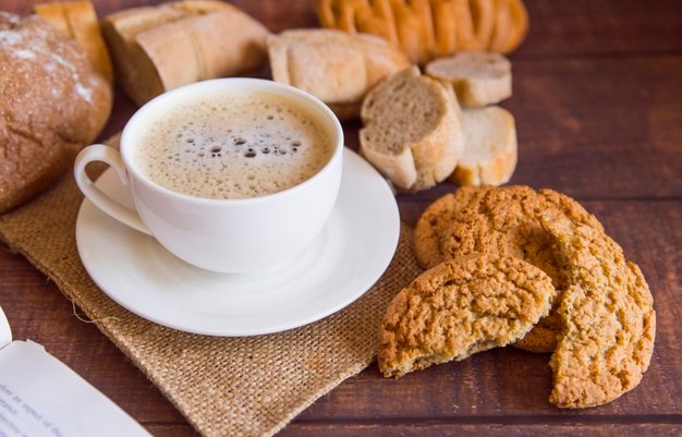 imagem de café sobre a mesa com paes e biscoitos
