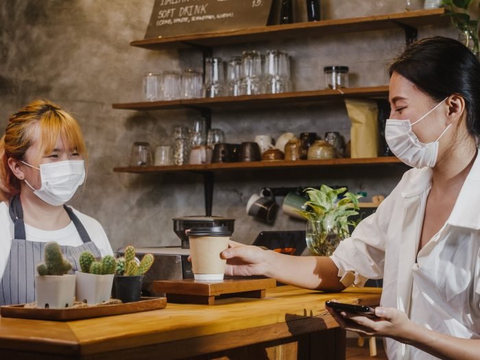 imagem de duas mulheres de mascaras faciais em cafeteria