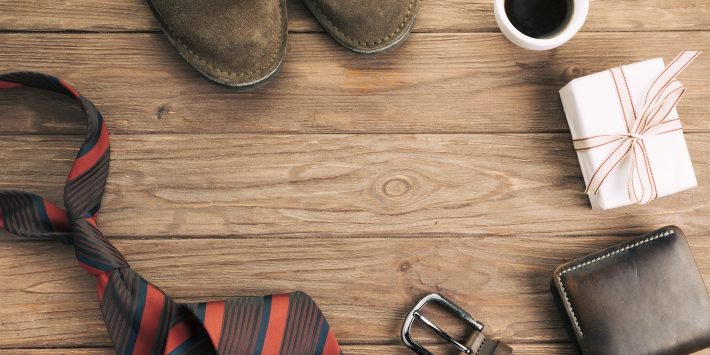 imagem xícara de café ao lado de sapatos e carteira gravata sobre a mesa de madeira