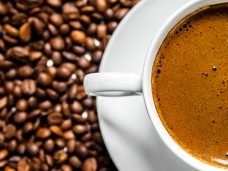 imagem xicara de cafe sobre graos de cafe