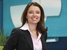 imagem mulher sorrindo vestindo camisa rosa e blazer preto