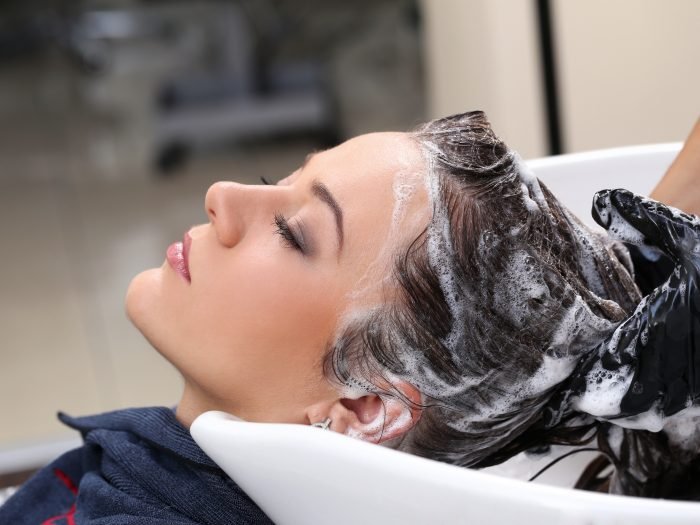 Hairdresser salon. Woman during hair wash