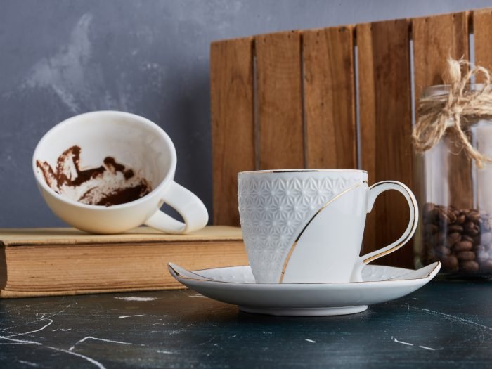 A cup of coffee with an empty one aside